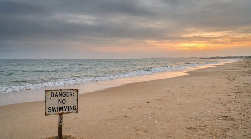 A weathered "Danger: No Swimming" warning sign planted on the shoreline of Diveagar Beach in Raigad, Maharashtra, where eight students drowned.